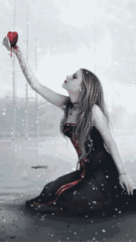 a woman in a black dress is holding a red heart with blood dripping from it