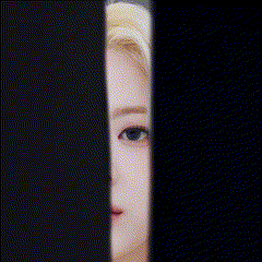 a close up of a woman 's face peeking through a black fence .
