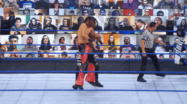 a wrestling match is going on in front of a crowd including one wearing a shirt that says " i can "