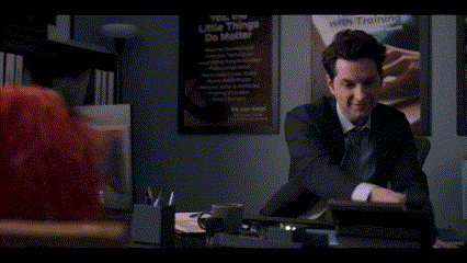 a man in a suit is talking on a cell phone to a red puppet