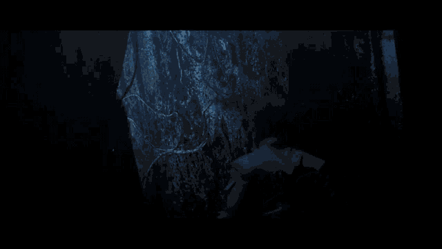 a silhouette of darth vader is standing in the dark