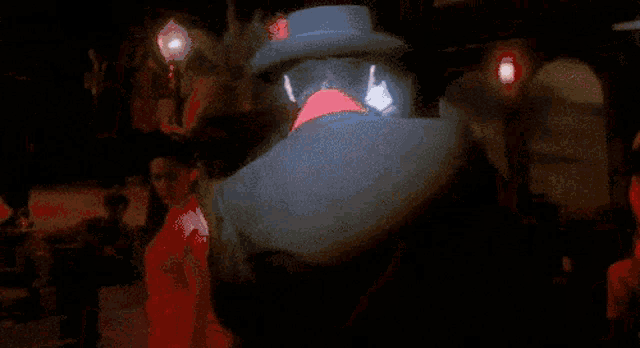a man wearing a hat and a red shirt is holding a light