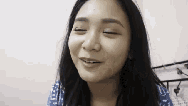 a close up of a woman 's face with her eyes closed and a smile on her face .