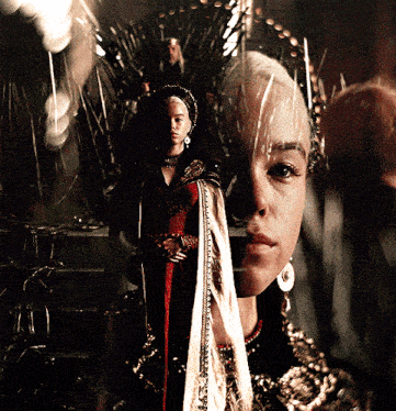 a woman is standing in front of a throne with a crown on her head