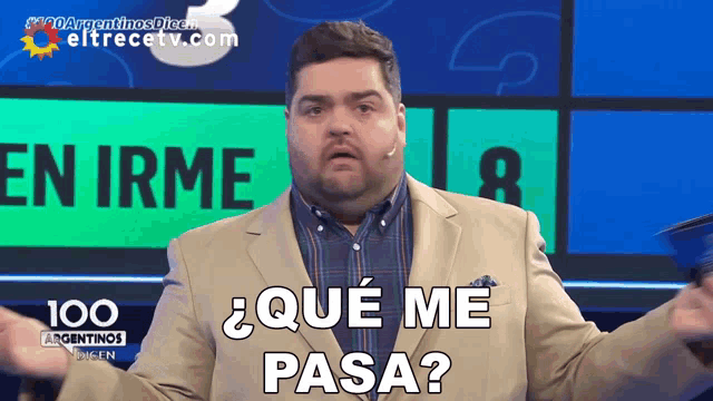 a man in a suit says " que me pasa " in front of a sign that says " en irme "