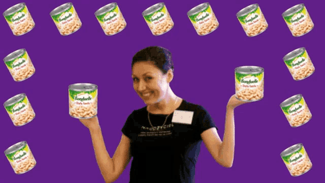 a woman is holding up a can of beans that says " tagliatelle " on it