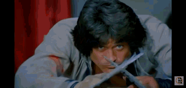 a man is holding a pair of scissors in his hand .