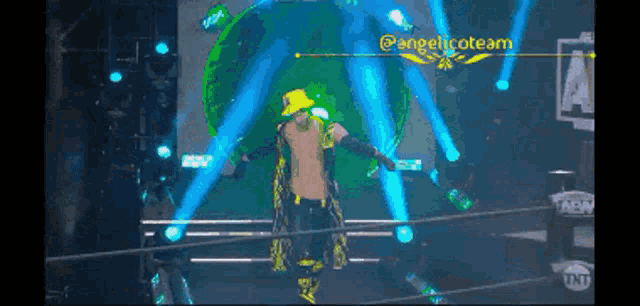 a man in a yellow top hat is walking out of a wrestling ring with a tnt logo in the background