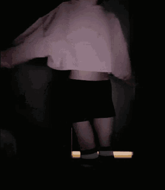 a woman in a pink crop top and black shorts
