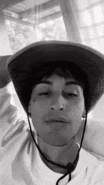 a man wearing a cowboy hat and a nose ring