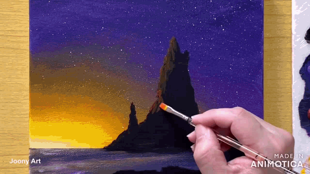 a person is holding a brush in front of a painting that says made in animatica on the bottom