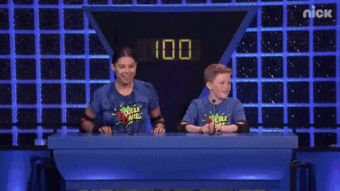 a girl and a boy are sitting at a table with the number 200 on it