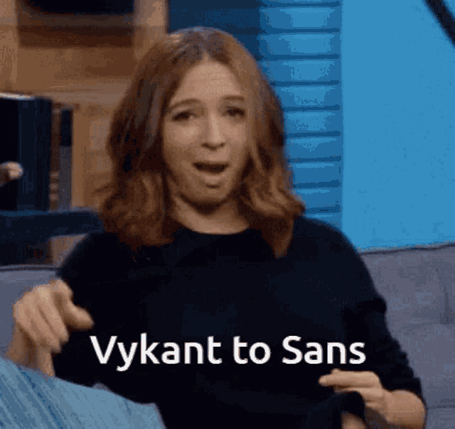 a woman is sitting on a couch with her mouth open and the words vykant to sans above her