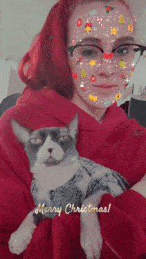 a woman is holding a cat with a merry christmas message on the bottom