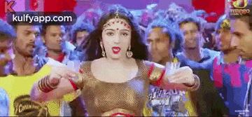 a woman is dancing in front of a crowd of people in a crowded room .