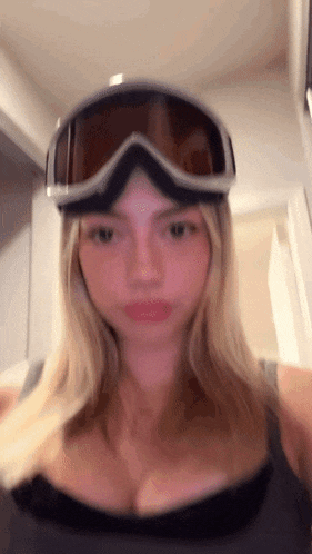 a woman is wearing a pair of ski goggles on her head