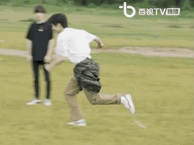 a blurry picture of a man running in a field with the letter b above him