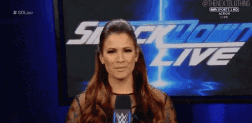 a woman is standing in front of a screen that says smack down live