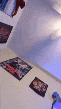 a room with posters on the wall including one that says ' spider-man '