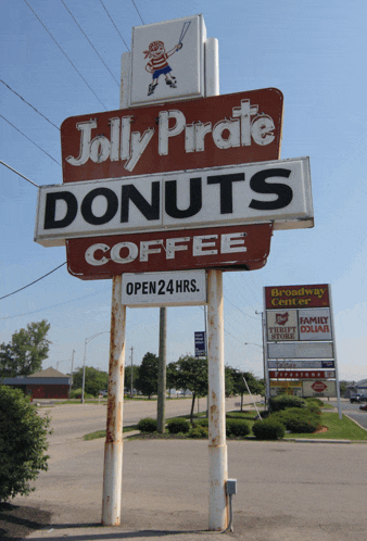 a sign for jolly pirate donuts coffee says it is open 24 hours