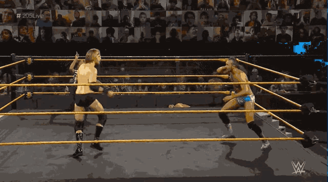 two wrestlers in a wrestling ring with the hashtag # 205live in the background