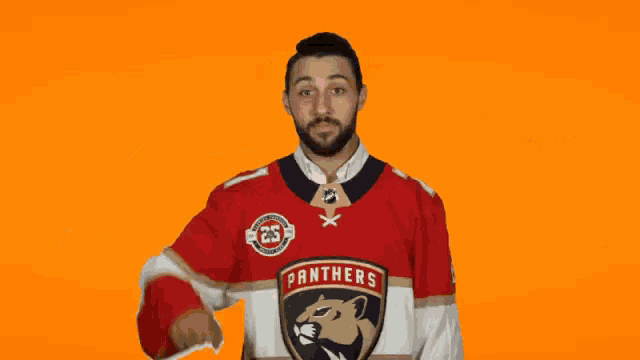 a man in a panthers jersey holds a pumpkin