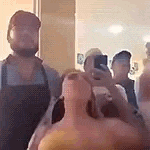 a group of people are standing in front of a mirror .