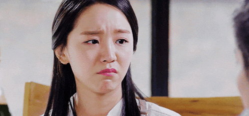 a close up of a woman 's face with a sad look on her face