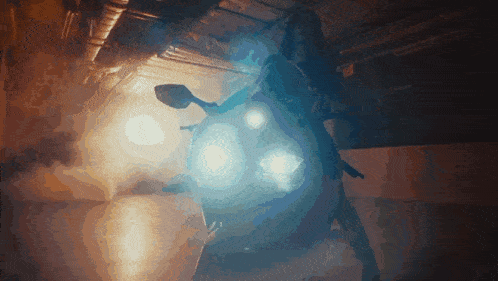a person riding a motorcycle in a dark room with smoke coming out of the back