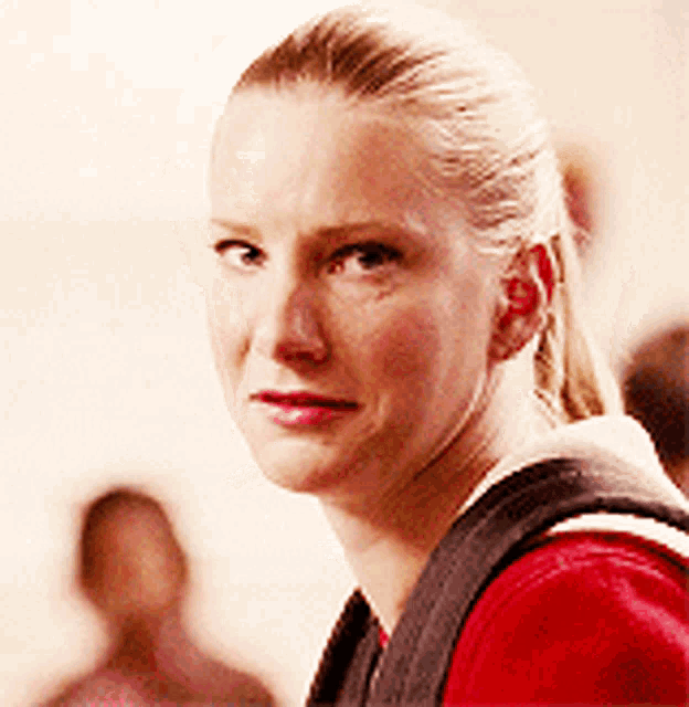 a close up of a woman 's face with a ponytail and a backpack
