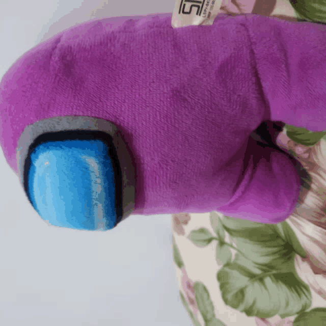 a purple stuffed animal has a tag that says sg on it