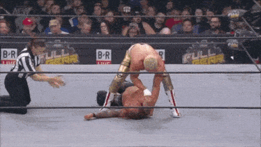 two wrestlers are wrestling in a ring with a full gear logo on the wall behind them