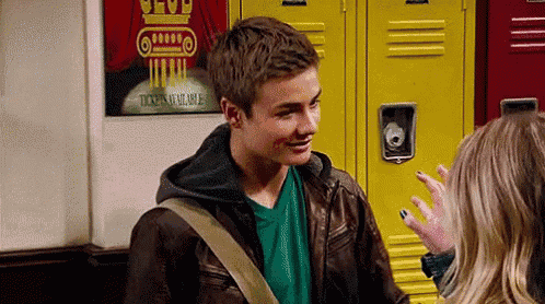 a boy and a girl are standing next to each other in front of lockers .