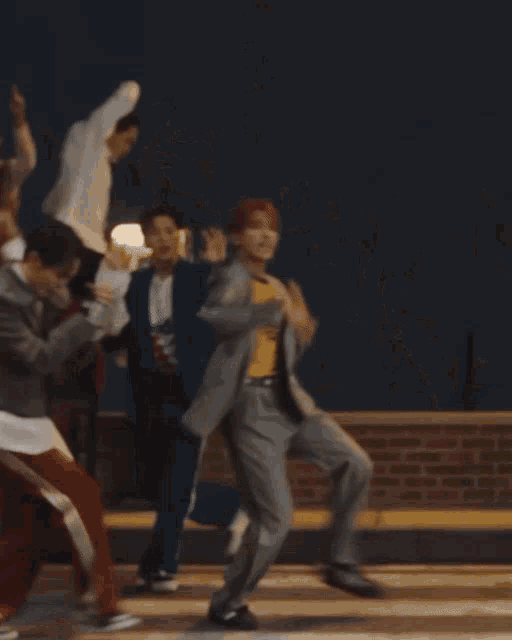 a group of young men are dancing with one wearing a yellow adidas t-shirt