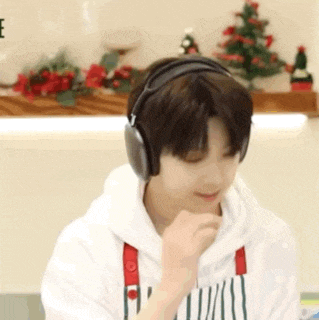 a young boy is wearing headphones and a white hoodie .