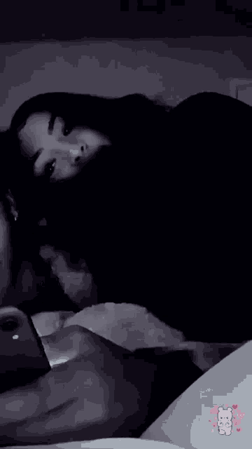 a black and white photo of two people laying on a bed with the letters bc on the bottom