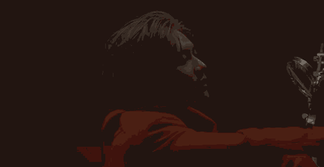 a man in a red suit is looking at himself in the mirror
