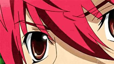 a close up of a girl 's eyes with red hair .