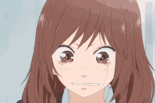 a close up of a girl with brown hair crying with tears coming out of her eyes .