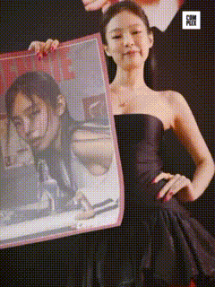 a woman in a black dress holding a picture of herself