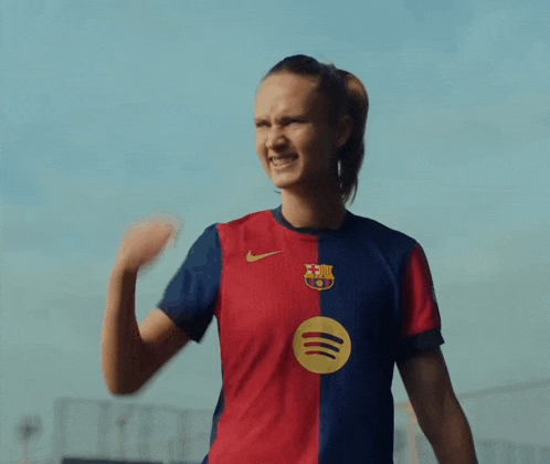 a woman wearing a soccer jersey with a spotify logo on the sleeve