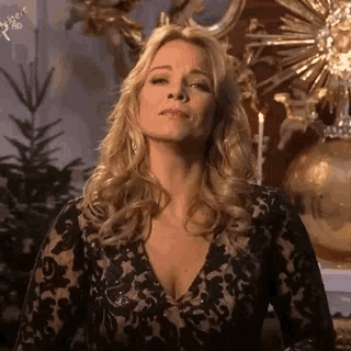 a woman in a black lace dress is making a face .