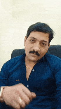 a man with a mustache is wearing a blue shirt and gold chain