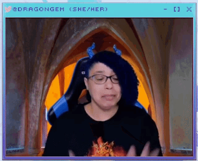a woman with blue hair and glasses is sitting in front of a window that says ' cdragongem ' on it