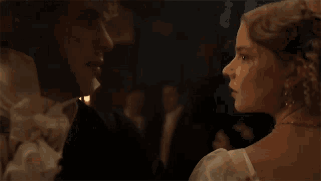 a man and a woman are dancing in a ballroom with candles in the background