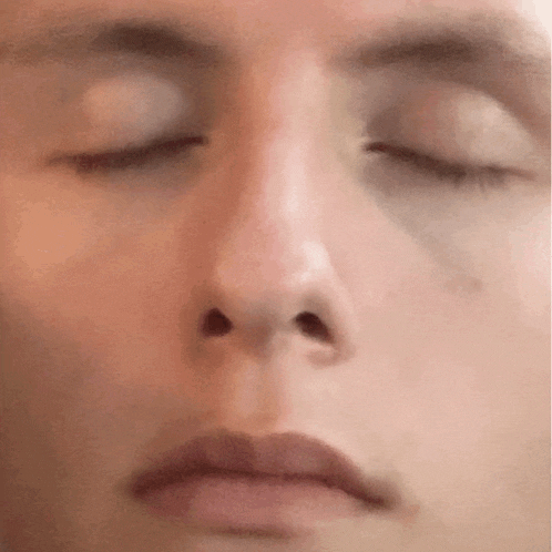 a close up of a person 's face with their eyes closed and their mouth open .