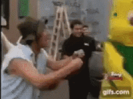 a man in a unicorn costume is standing next to a yellow and green cartoon character .