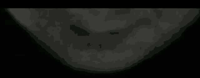 a close up of a person 's face in the dark with a blurry background .
