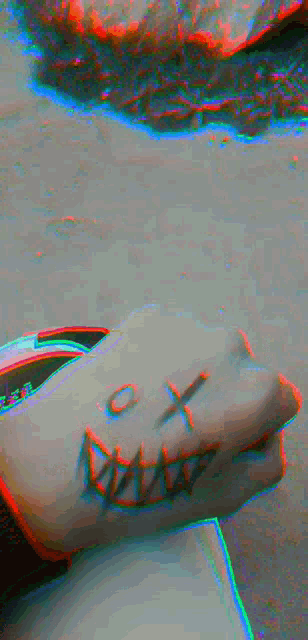 a person has a tattoo of a smiley face on their wrist