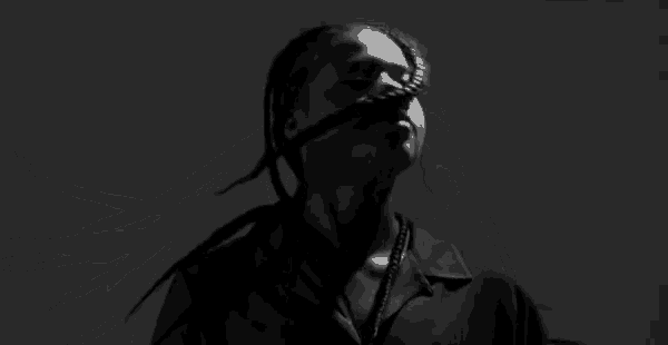 a black and white photo of a woman with dreadlocks and braids .